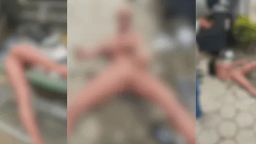 As imagens mostram os garis manuseando a boneca e utilizando um cabo de vassoura de forma inapropriada.