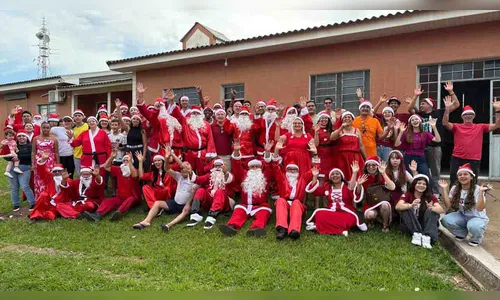 Voluntários vestidos de Papai Noel distribuem brinquedos em Ivaiporã