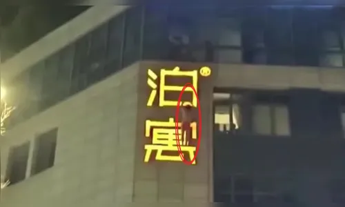 Amante fica pendurado na placa de prédio para fugir de flagra sexual
