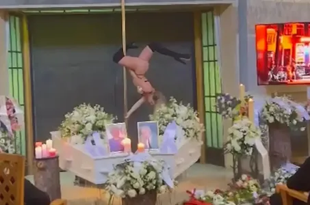 Dançarina faz show de pole dance entre caixões em velório de donos de casa noturna