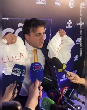 Renan Santos leva fraldas com nomes de Lula e Flávio em debate e critica ausência em debate