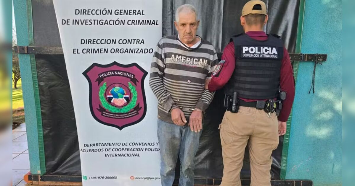 Homem sendo conduzido por policiais durante a prisão na fronteira entre Paraguai e Brasil.