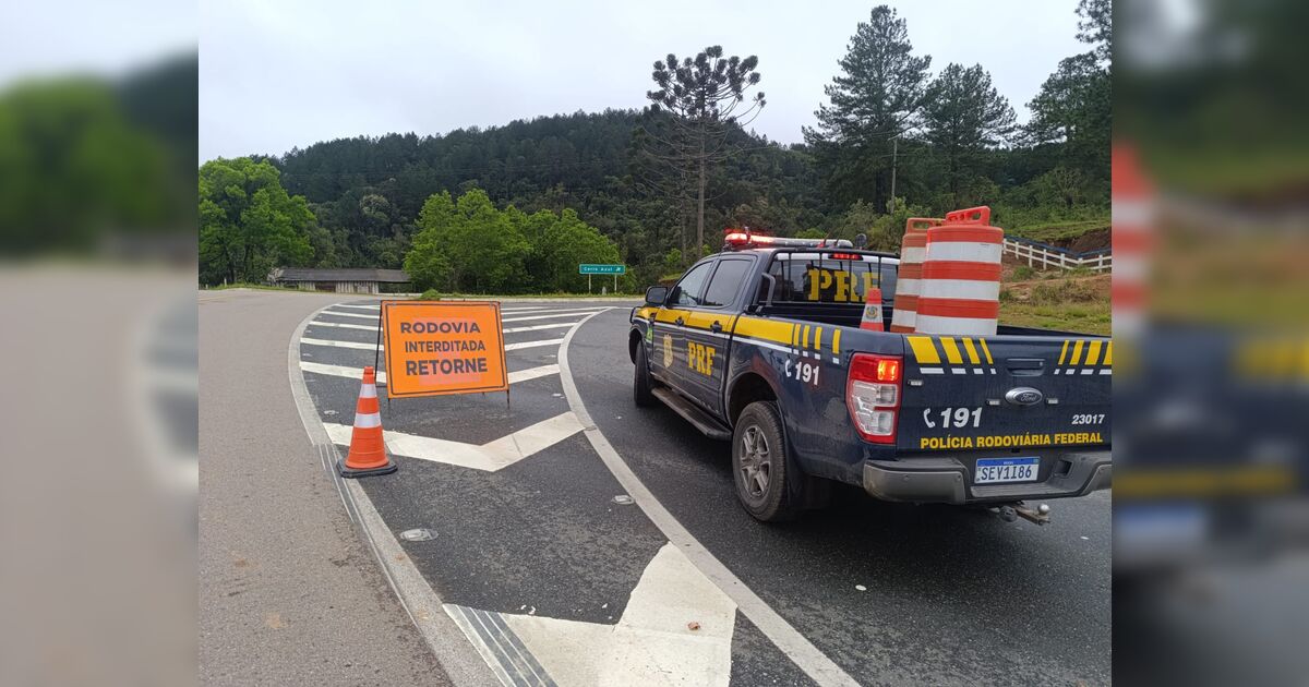 Trecho interditado da rodovia BR-476 com pedras e terra bloqueando a pista.