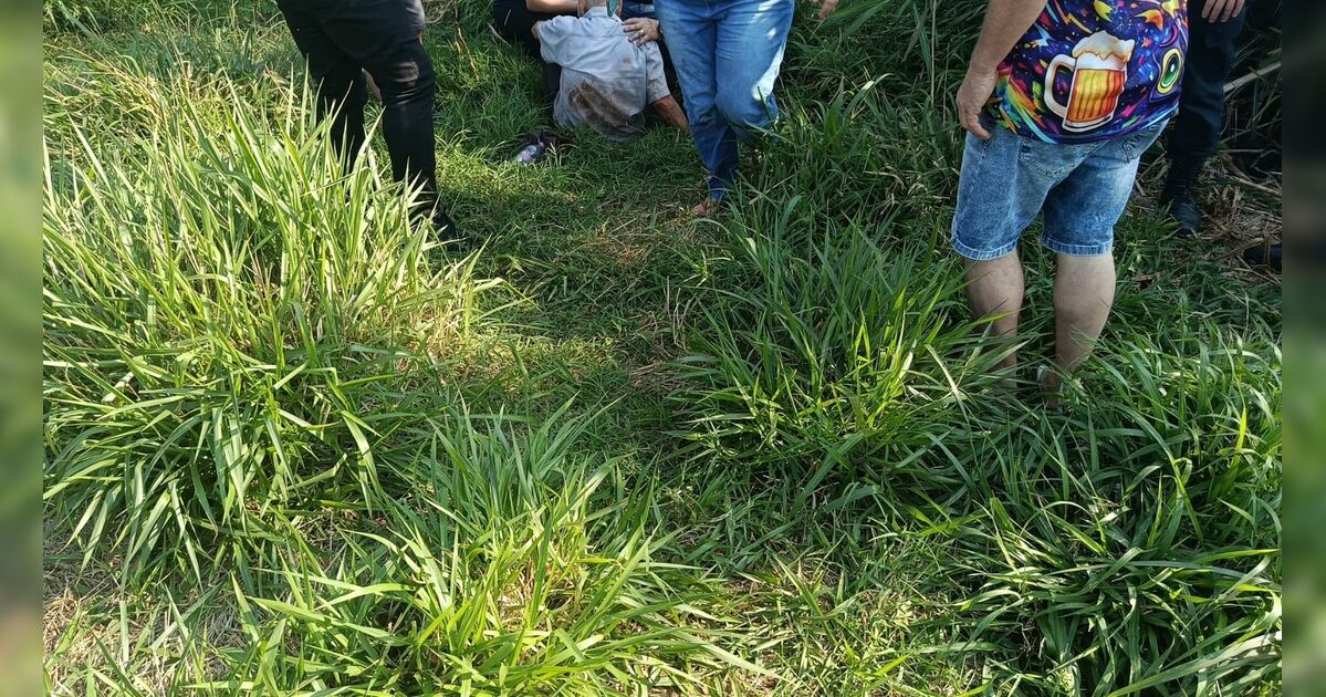 Idoso sentado no chão com camisa suja de terra após ser encontrado em área de mata