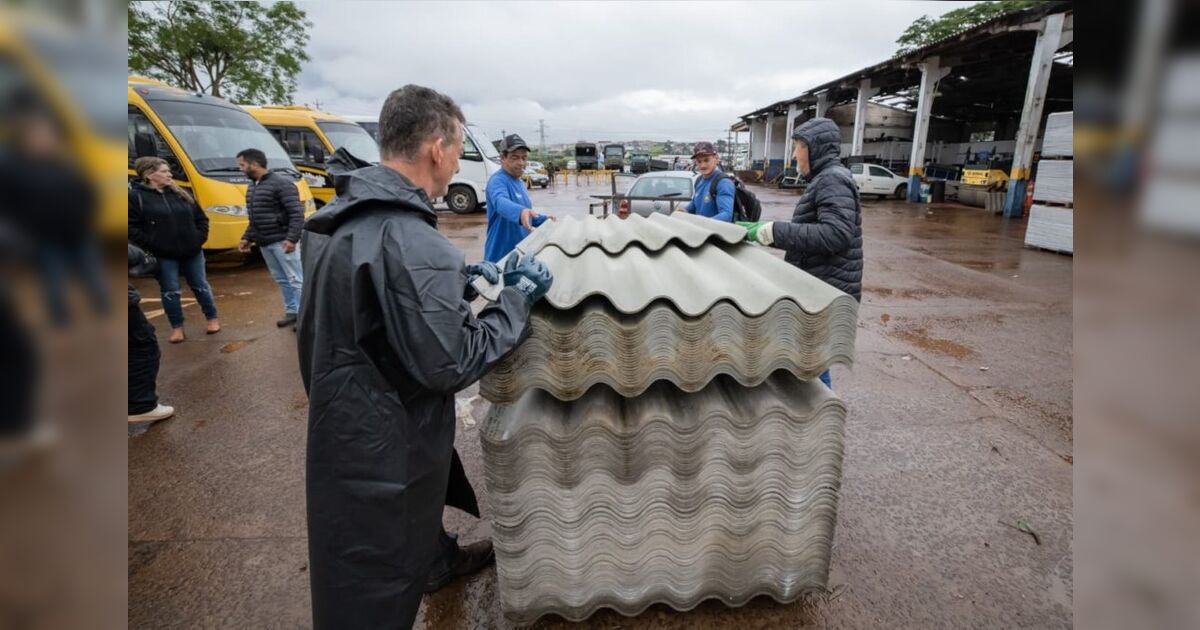 Equipes de emergência e moradores na fila de distribuição de telhas em Apucarana