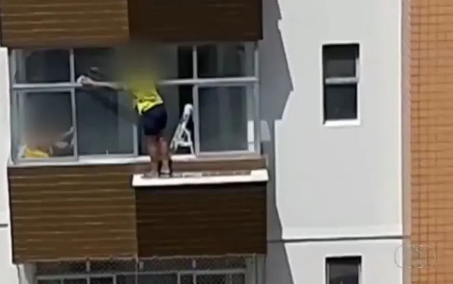 Mulher se arrisca para limpar janela do lado de fora no 6° andar de prédio