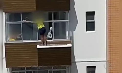 Mulher se arrisca para limpar janela do lado de fora no 6° andar de prédio