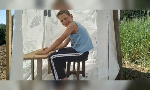 Criança estuda em cabana montada no meio de plantação para conseguir sinal de internet