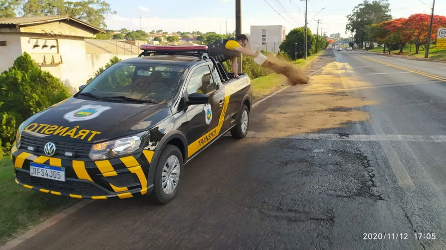 Agentes de trânsito aplicam serragem na rodovia com óleo derramado