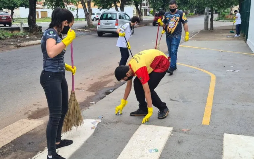 Estudantes varrem e recolhem santinhos jogados nas ruas de Goiânia
