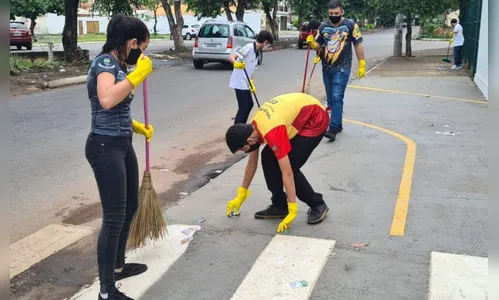 Estudantes varrem e recolhem santinhos jogados nas ruas de Goiânia
