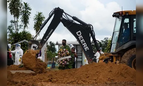 Em Manaus, retroescavadeiras são usadas para abrir covas
