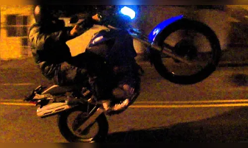 Homem empina moto, acelera na contramão e bate em ônibus