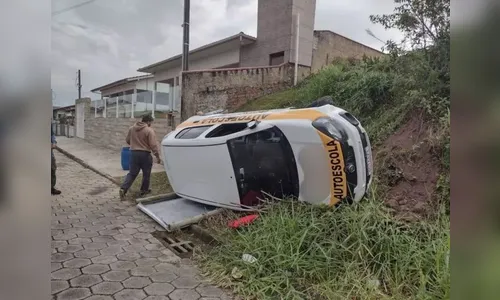 Mulher capota carro de autoescola em prova da baliza