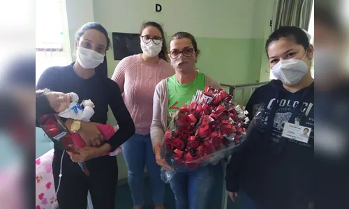 Voluntária entrega rosas para mães internadas no Providência