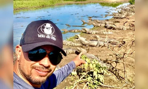 Homem pedala em meio a vários jacarés no Pantanal; Vídeo