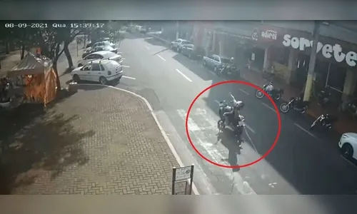 Motociclista cai após se enroscar em cabo solto na rua