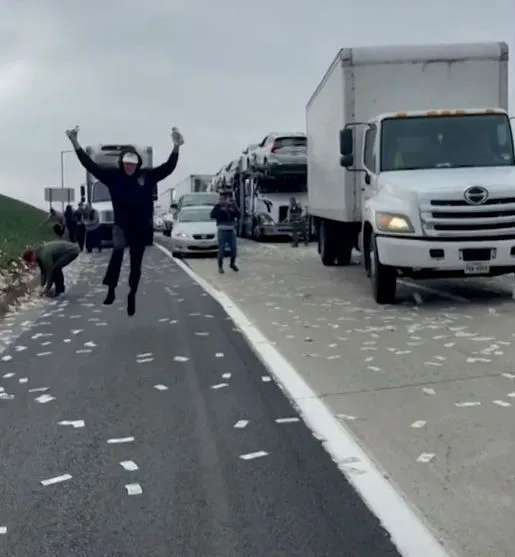 A rodovia chegou a ser completamente bloqueada e diversas pessoas pararam seus carros para recolher as notas