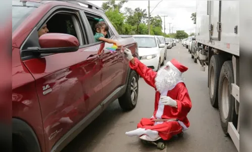 De skate, Papai Noel dribla carros e dificuldades na capital