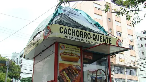 Homem improvisa barraca e dorme sobre quiosque de lanche
