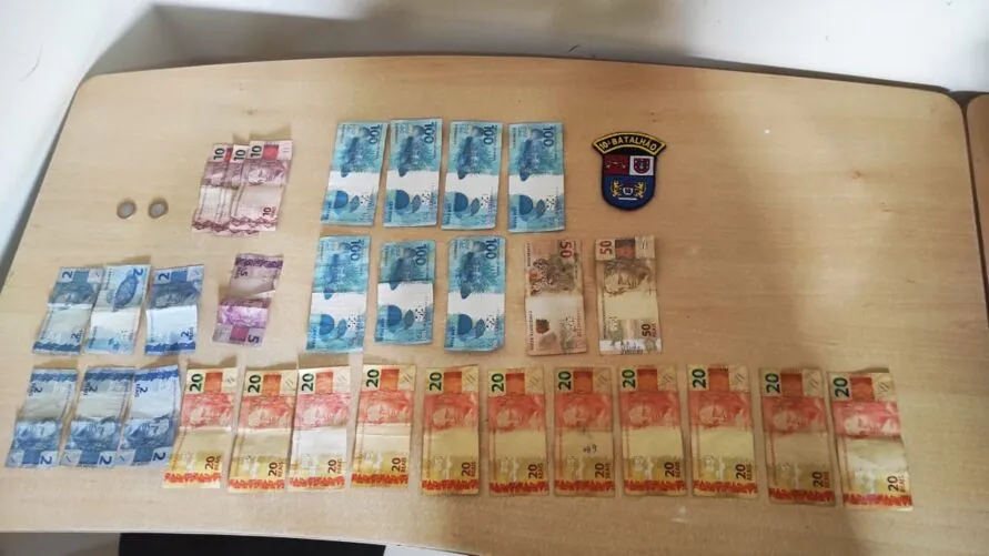 Cinco notas falsas de R$ 100 e dinheiro trocado dos criminosos foram apreendidos