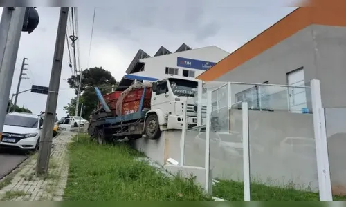 Caminhão caçamba desgovernado bate em muro e invade loja