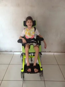 Lucas, de 8 anos, com sua nova cadeira dada pela Diocese de Apucarana