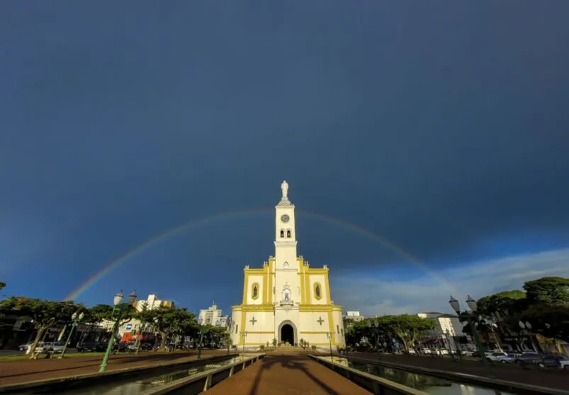 Foto mostra a Catedral de Apucarana e um arco-íris