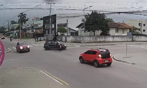 Motociclista atinge carro, dá cambalhota e sai andando; veja vídeo