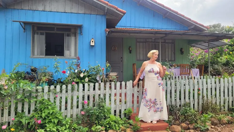 Vera Fornaciari em frente à casa do sítio onde funciona a "Varandinha Encantada"