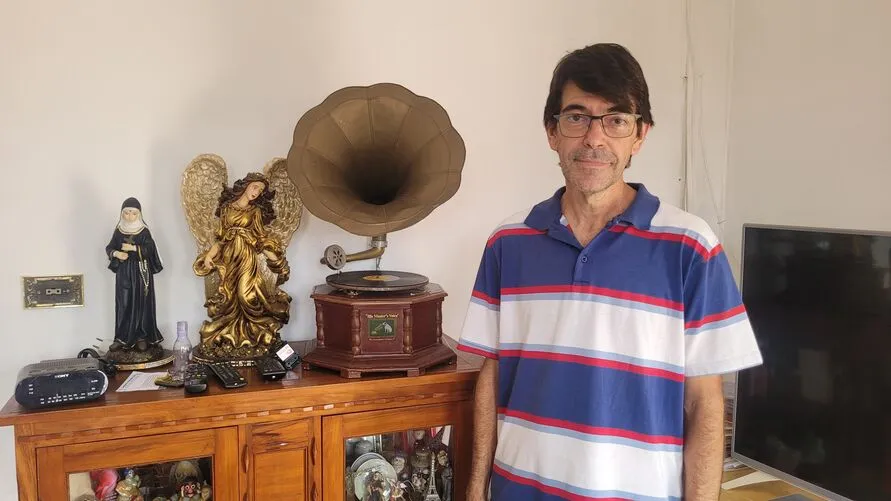 Gean Carlo ao lado de um gramofone que estará disponível no antiquário