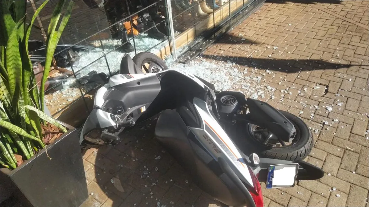 A motocicleta atingiu a vitrine de uma loja