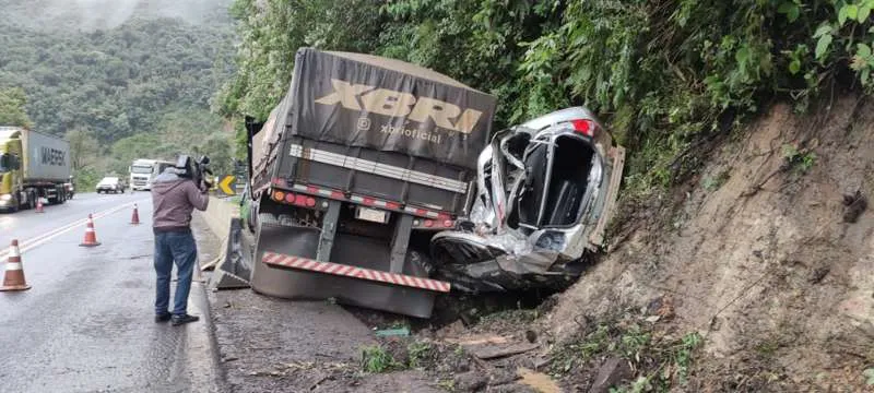 O automóvel foi prensado pelo caminhão contra o barrancO