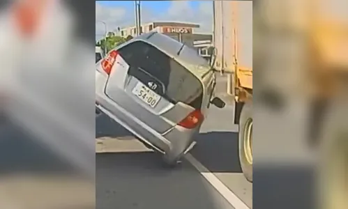 Porta de caminhão baú mal fechada arrasta e capota carro; veja vídeo