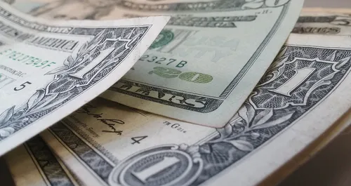 Dólar sobe com commodities fracas e realização após 3 quedas