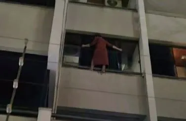 Mulher pendurada em prédio em Goiânia