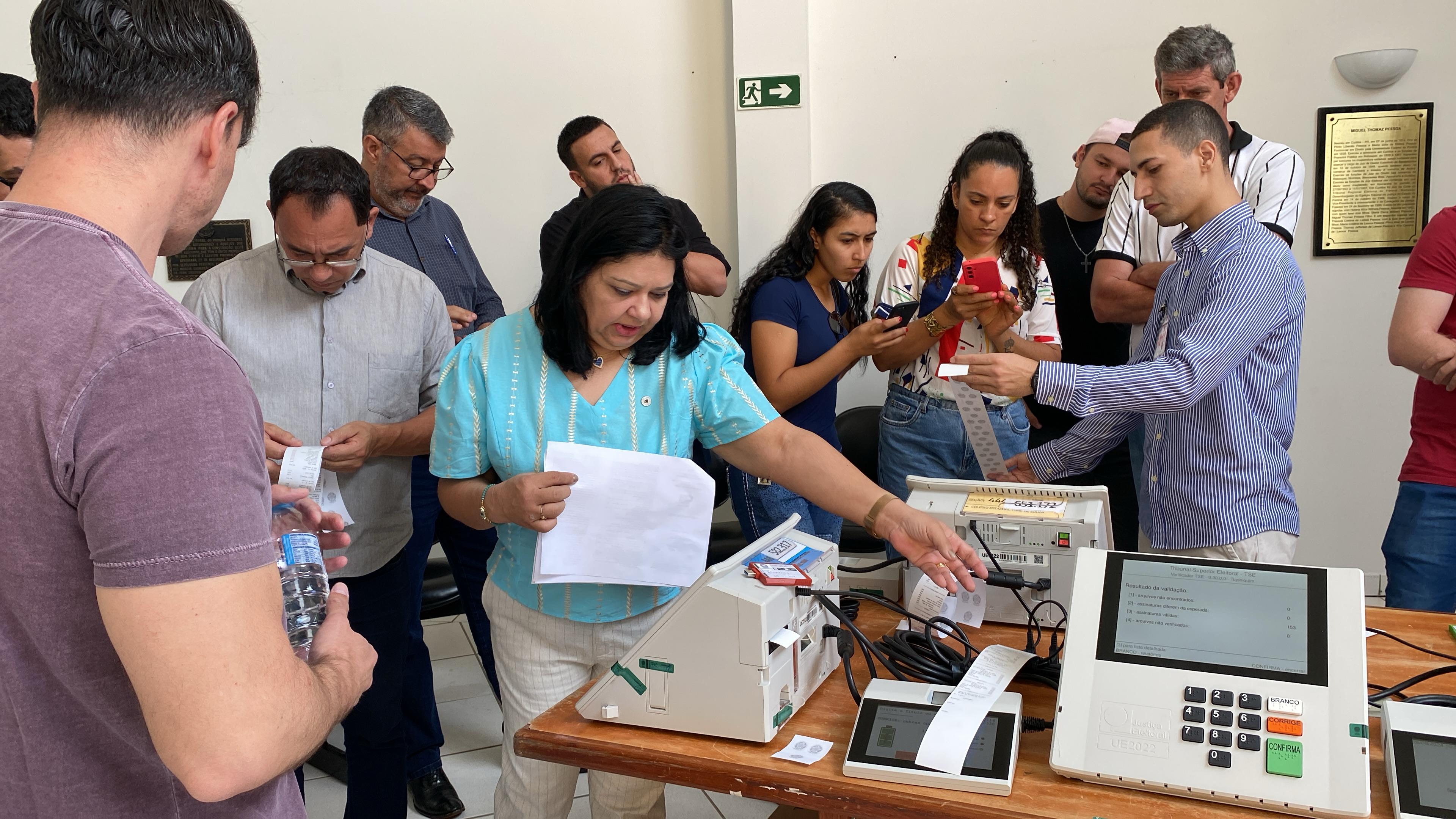 Os testes realizados incluem a verificação da integridade das urnas