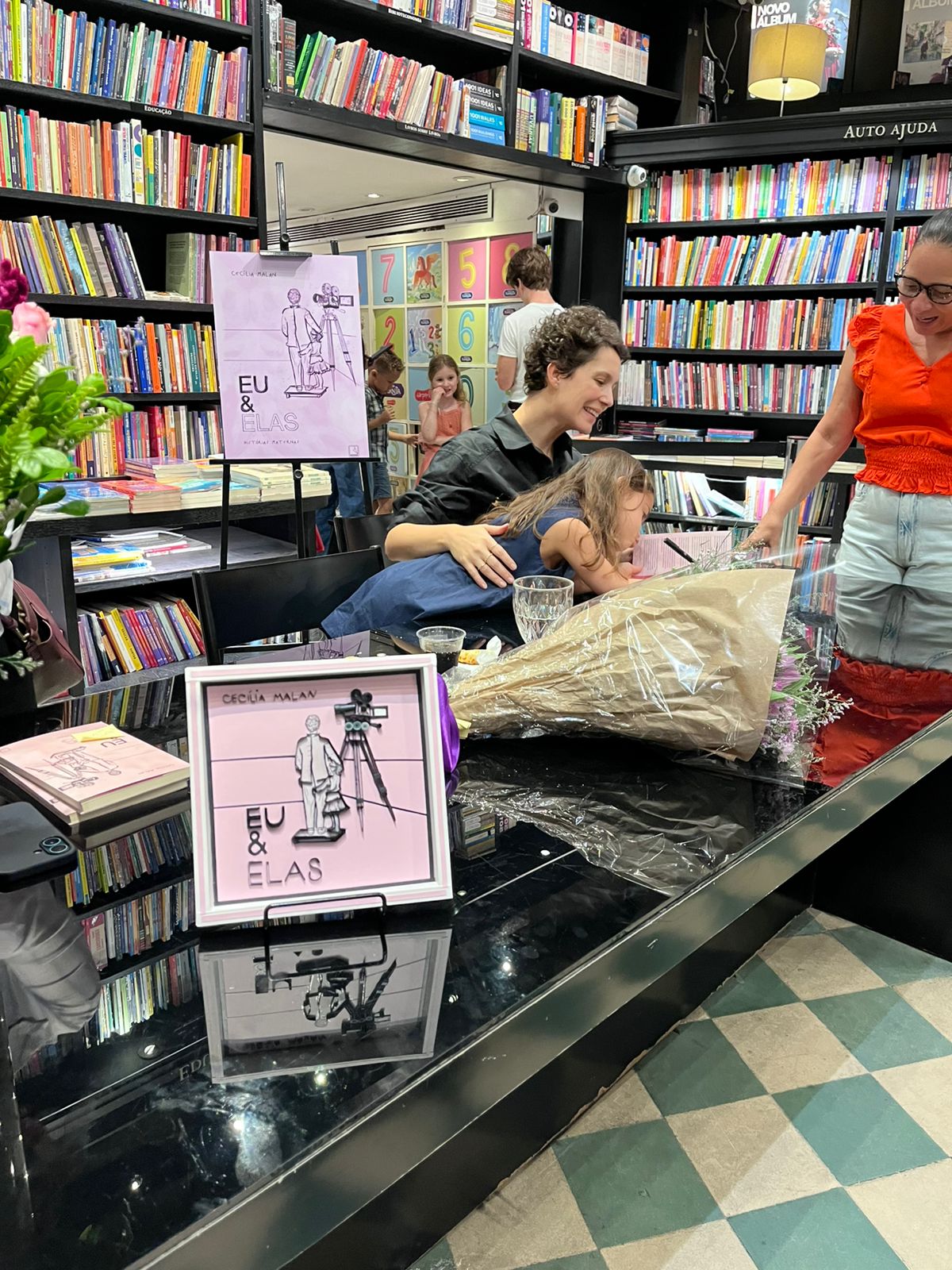 Ao lado da filha Olímpia, Cecília Malan autografa livros no evento de lançamento.