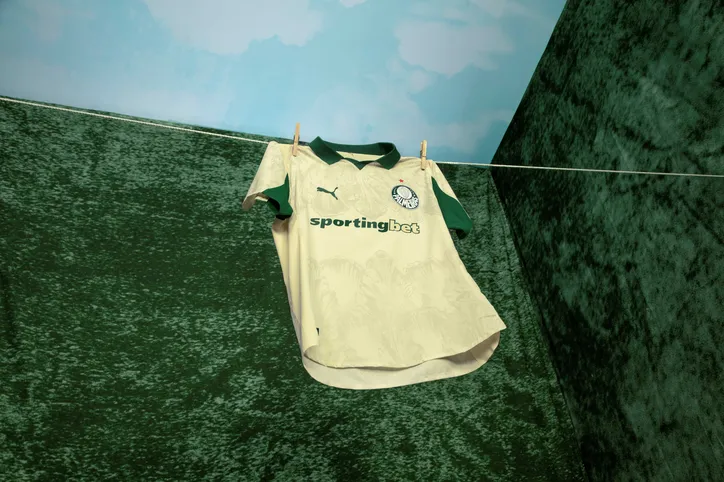A camisa tem uma base dourada, com folhas como "marca d'água" tanto na parte superior quanto na inferior