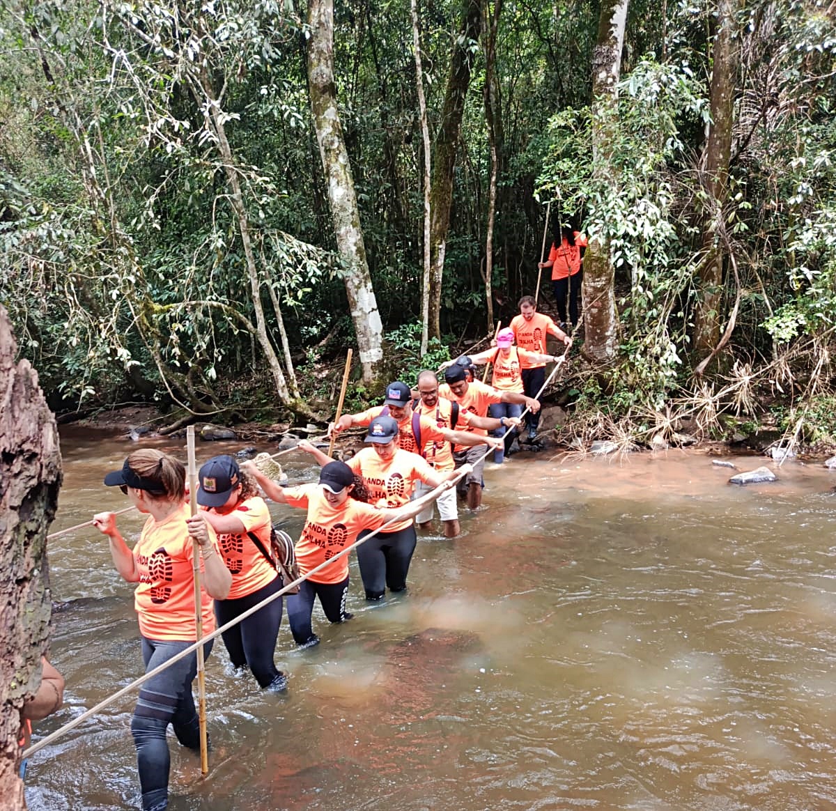 Turistas atravessam rio