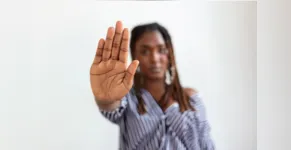  woman raised her hand for dissuade, campaign stop violence against women. African American woman raised her hand for dissuade with copy space 