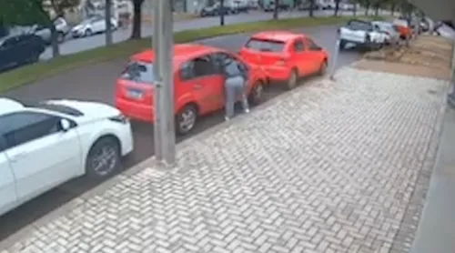 Momento em que a mulher quebra vidro do carro
