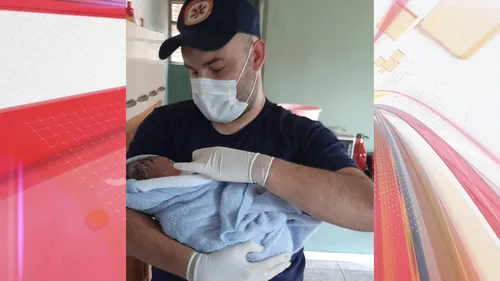 O bebê e um de seus heróis: socorrista Guilherme Borghesan segura a criança recém-nascida após o parto bem sucedido