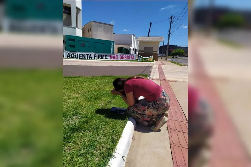 Imagem de mulher rezando em frente de hospital chama atenção