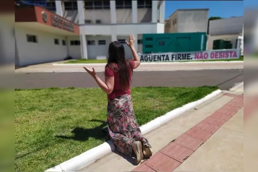 Imagem de mulher rezando em frente de hospital chama atenção