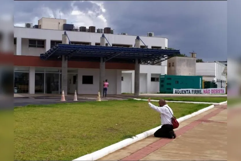 Imagem de mulher rezando em frente de hospital chama atenção