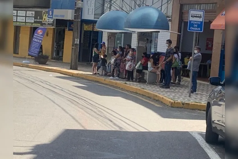  No ponto de ônibus, muita gente ainda de máscaras 