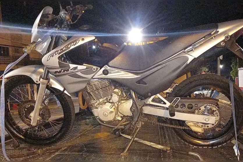  Um deles com sinais de embriaguez, portando uma garrafa de bebida e o outro, em frente a motocicleta, com o capacete na cabeça 