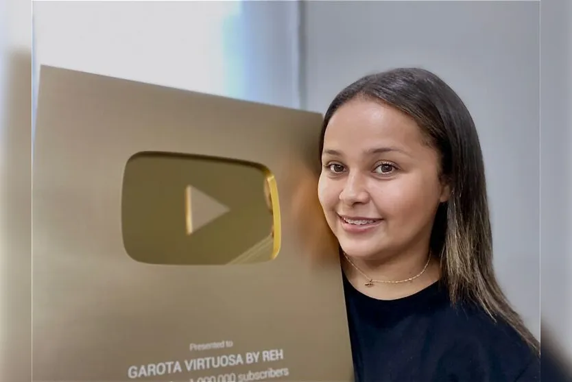  Renata exibe a placa de 1 milhão de seguidores no YouTube 