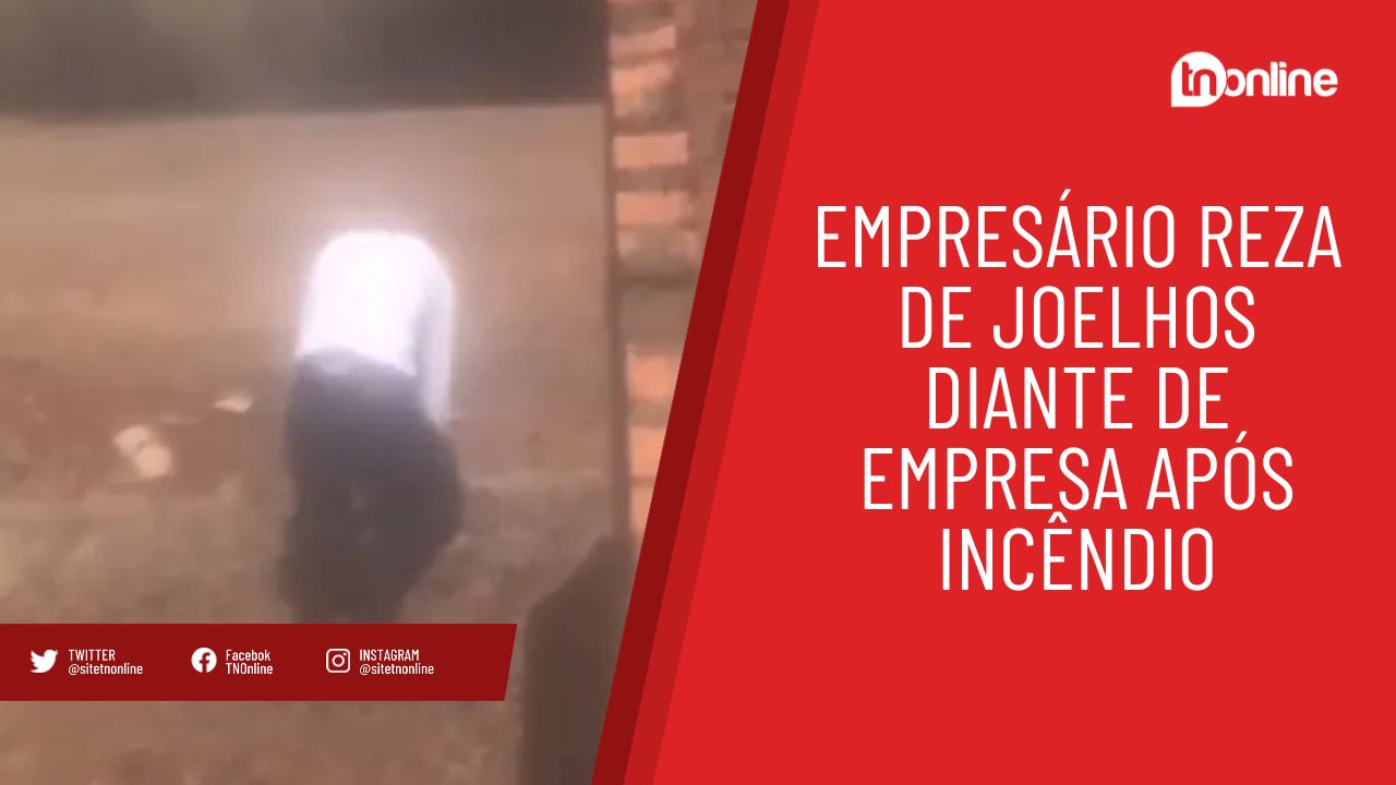 Empresário reza de joelhos diante de incêndio em sua empresa